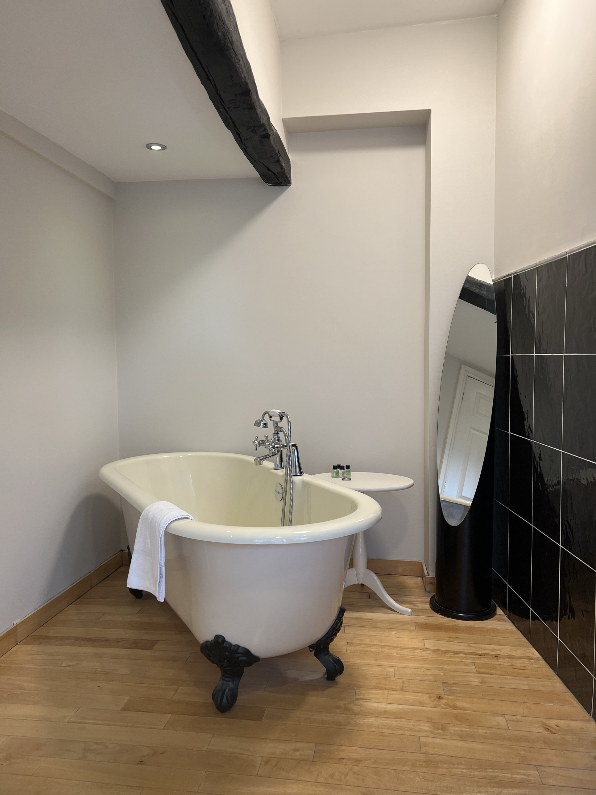 Freestanding clawfoot bath beneath an original exposed beam at The Silk House