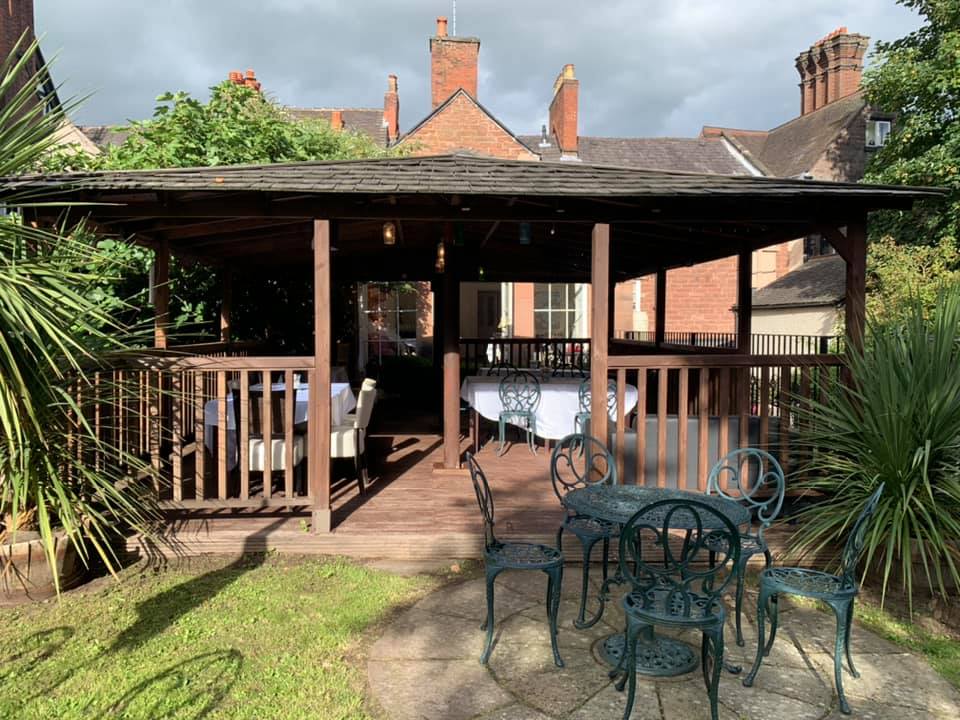 Covered gazebo with dining tables set up in The Silk House beer garden