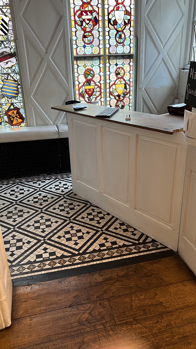 Reception desk beneath original stained glass windows
