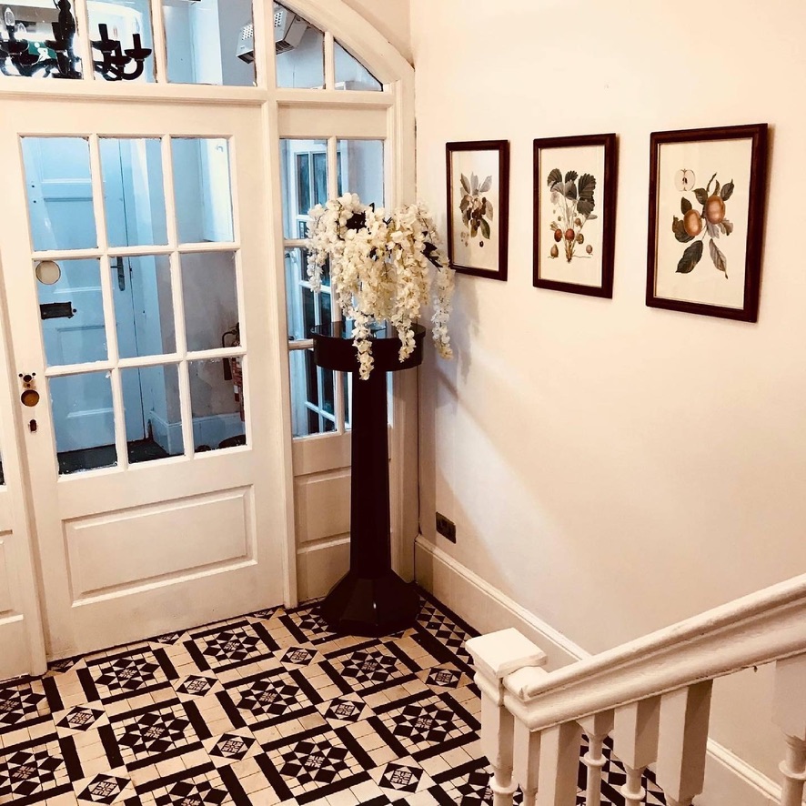 Reception hallway with original black and white tiled floor and stained glass windows