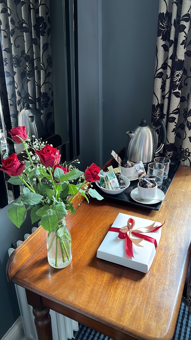 Guest room tea tray with fresh roses and a gift box at The Silk House